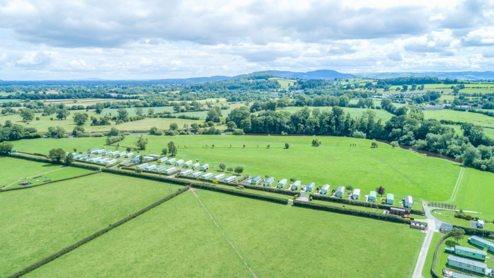 An aerial view that shows the countryside of Mid Wales with a row of caravans